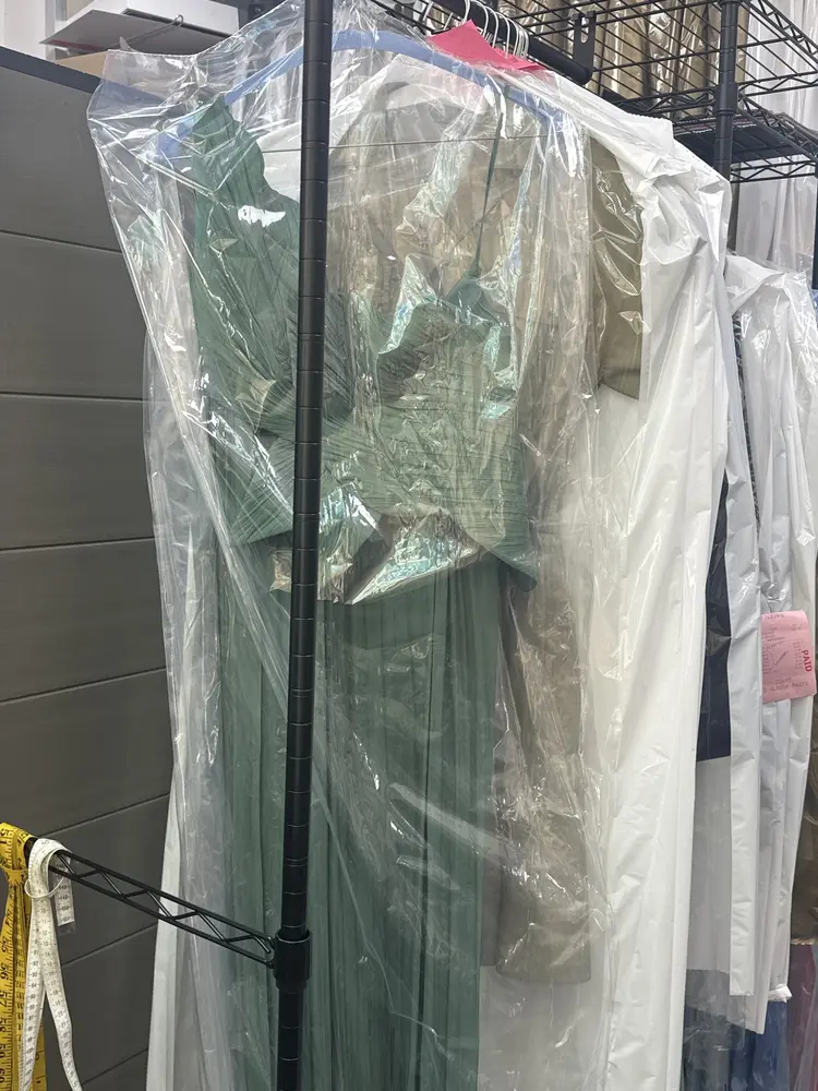 Dresses and jackets in clear garment bags on the shop rail